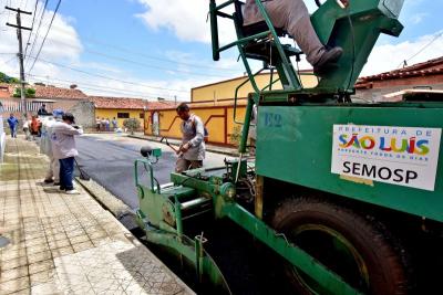 homens trabalham em asfaltamento de avenida