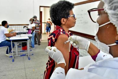 agente de saúde aplica vacina em idosa