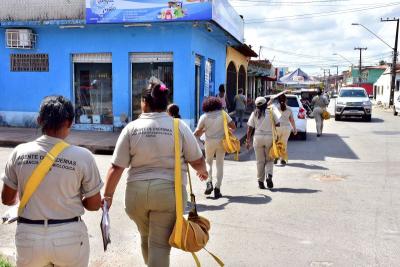 agentes de saúde caminham em avenida